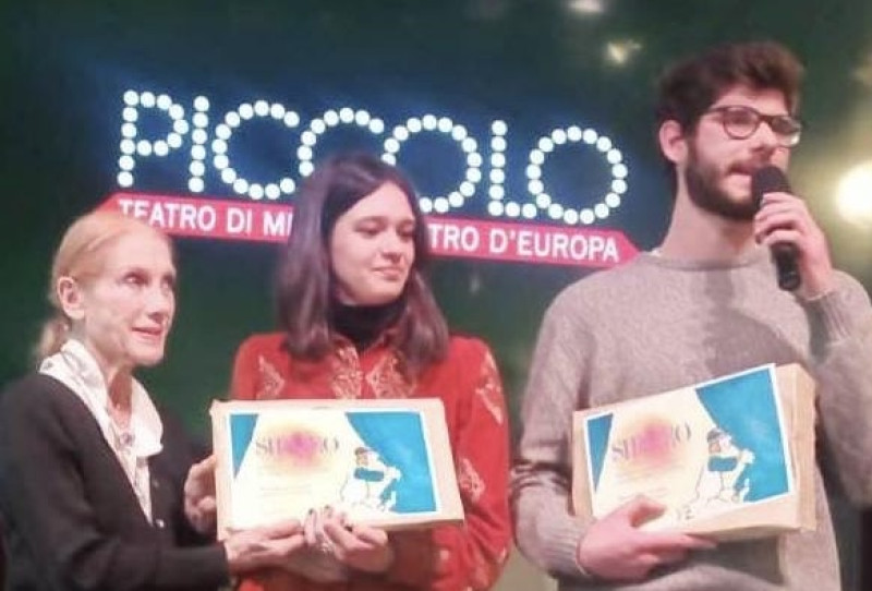 La drammaturga Violetta Chiarini, nella sede del Piccolo Teatro di Milano, nel corso della cerimonia del Concorso Autori Italiani, riceve la targa che attesta la sua vittoria per il suo testo “Von Karajan l’avrebbe fatto un baffo”. 